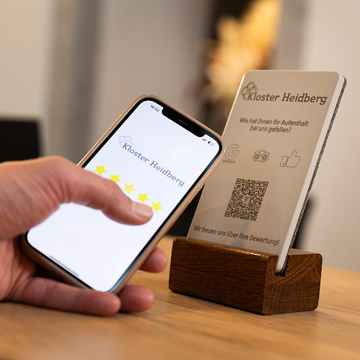 Beispielbild zur Erklärung des NFC Aufstellers von brique. Handy an den Tischaufsteller halten und den Anweisungen auf dem Display folgen.